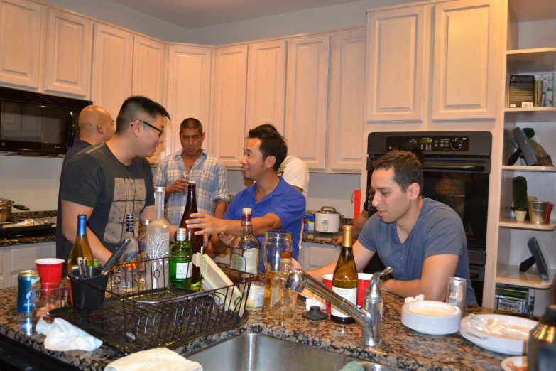 a group of men standing around in a kitchen