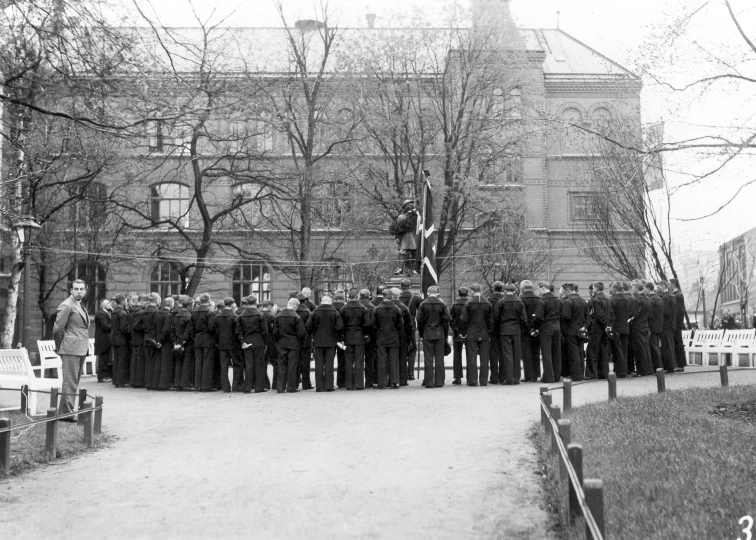 several men wearing long suits standing in front of an old building