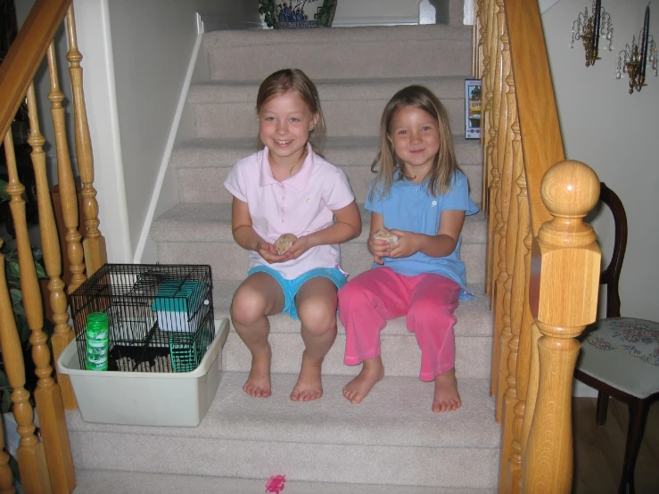two girls are sitting on some stairs with food