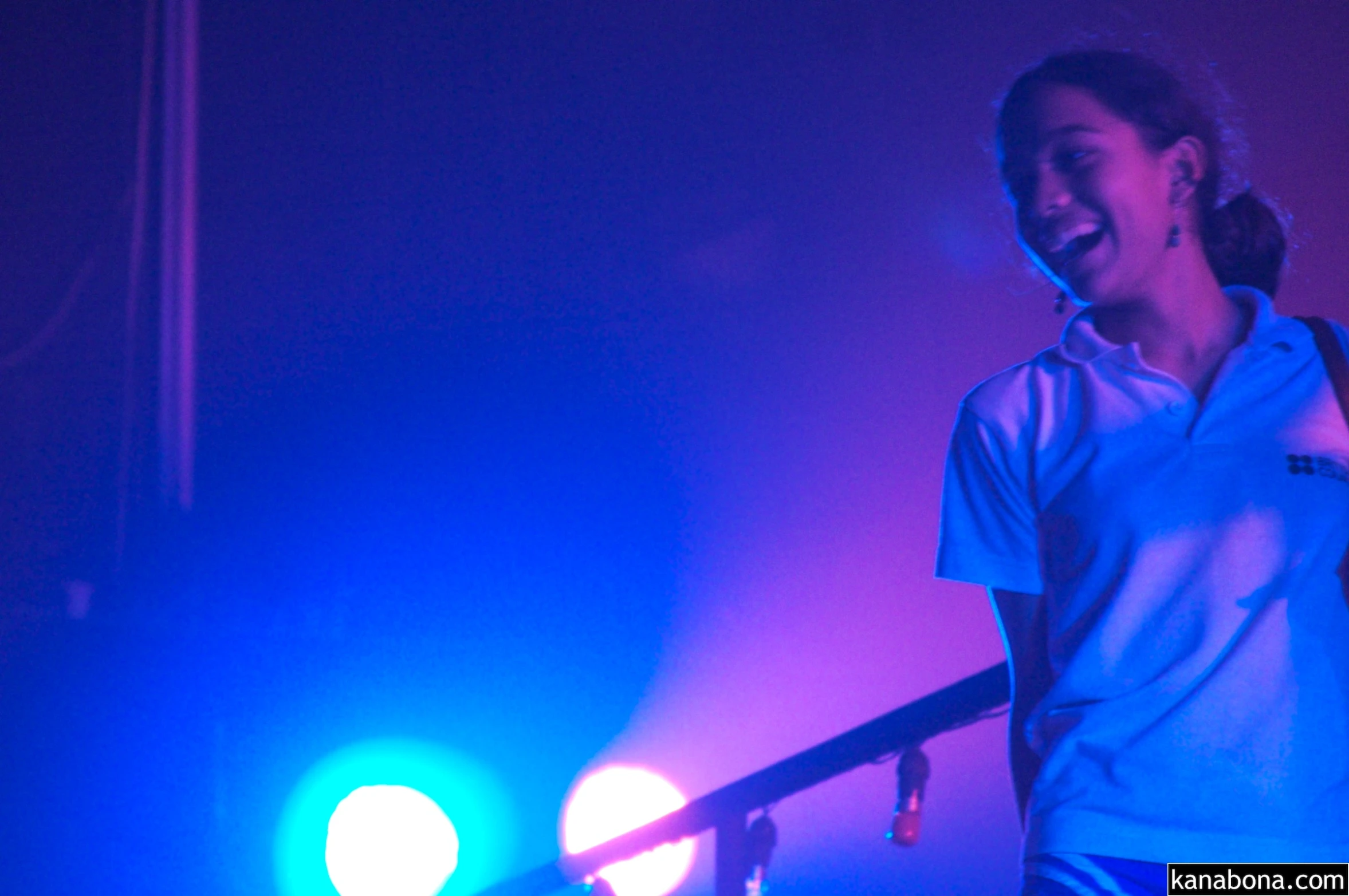 a woman on stage smiling as the lights turn on