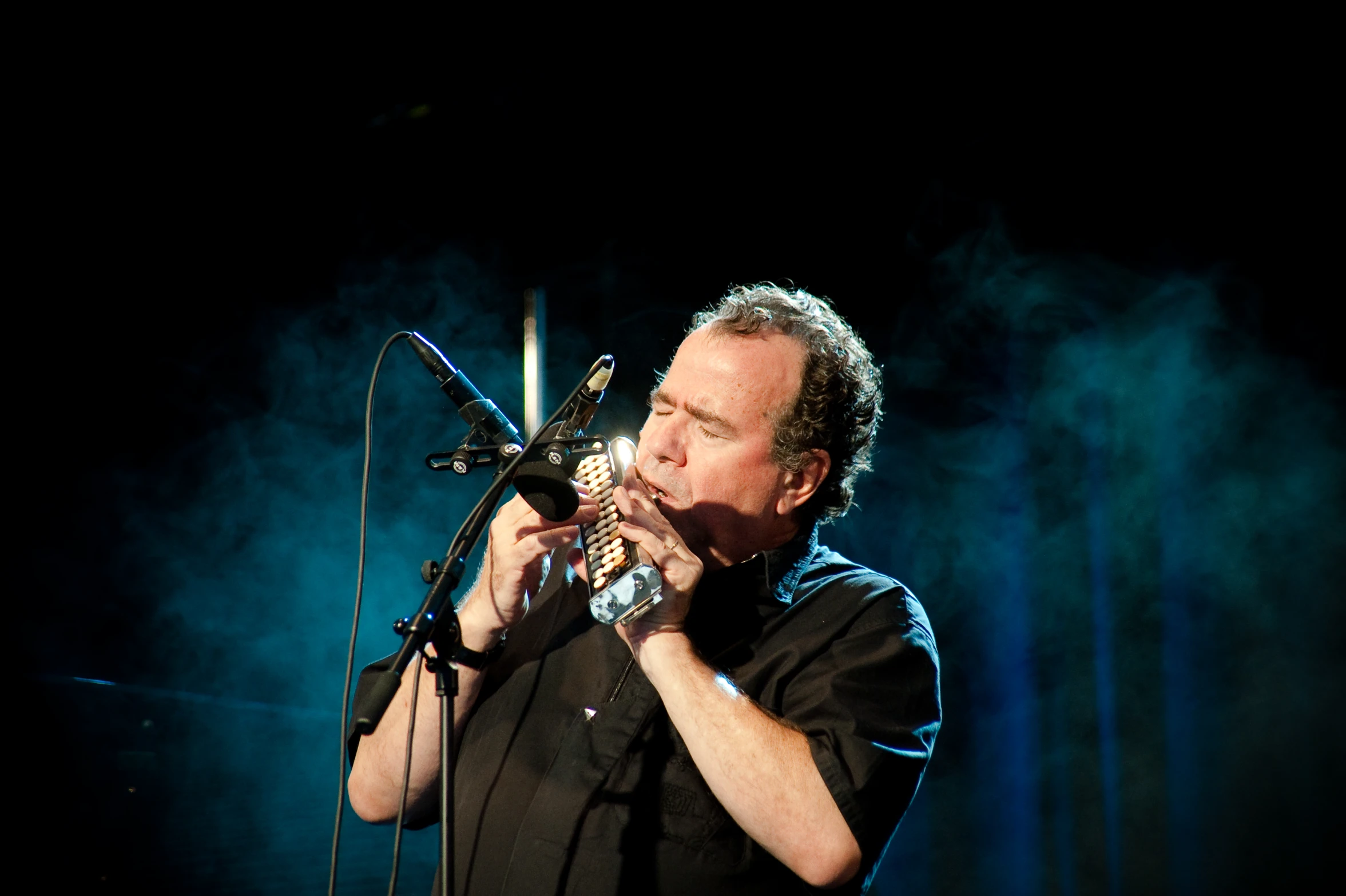 a man singing into a microphone at night