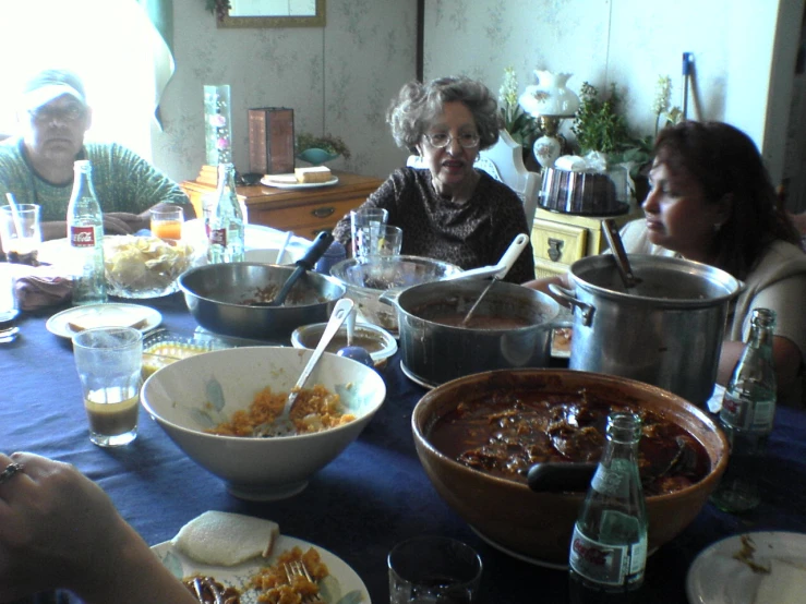 some people are sitting at a table with many food