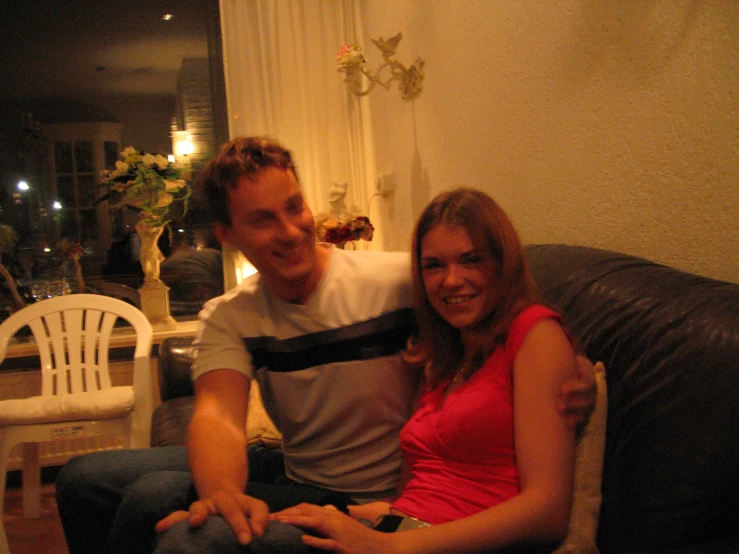 two people on a couch are laughing and smiling