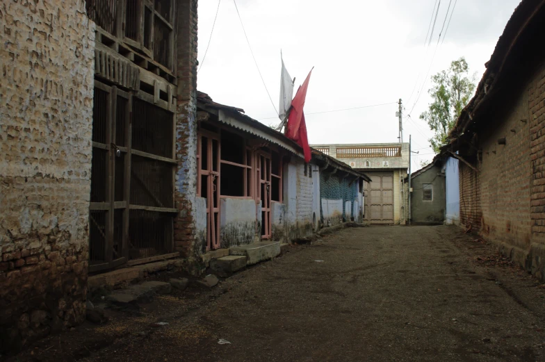 an empty alley between two buildings has a red fire hydrant