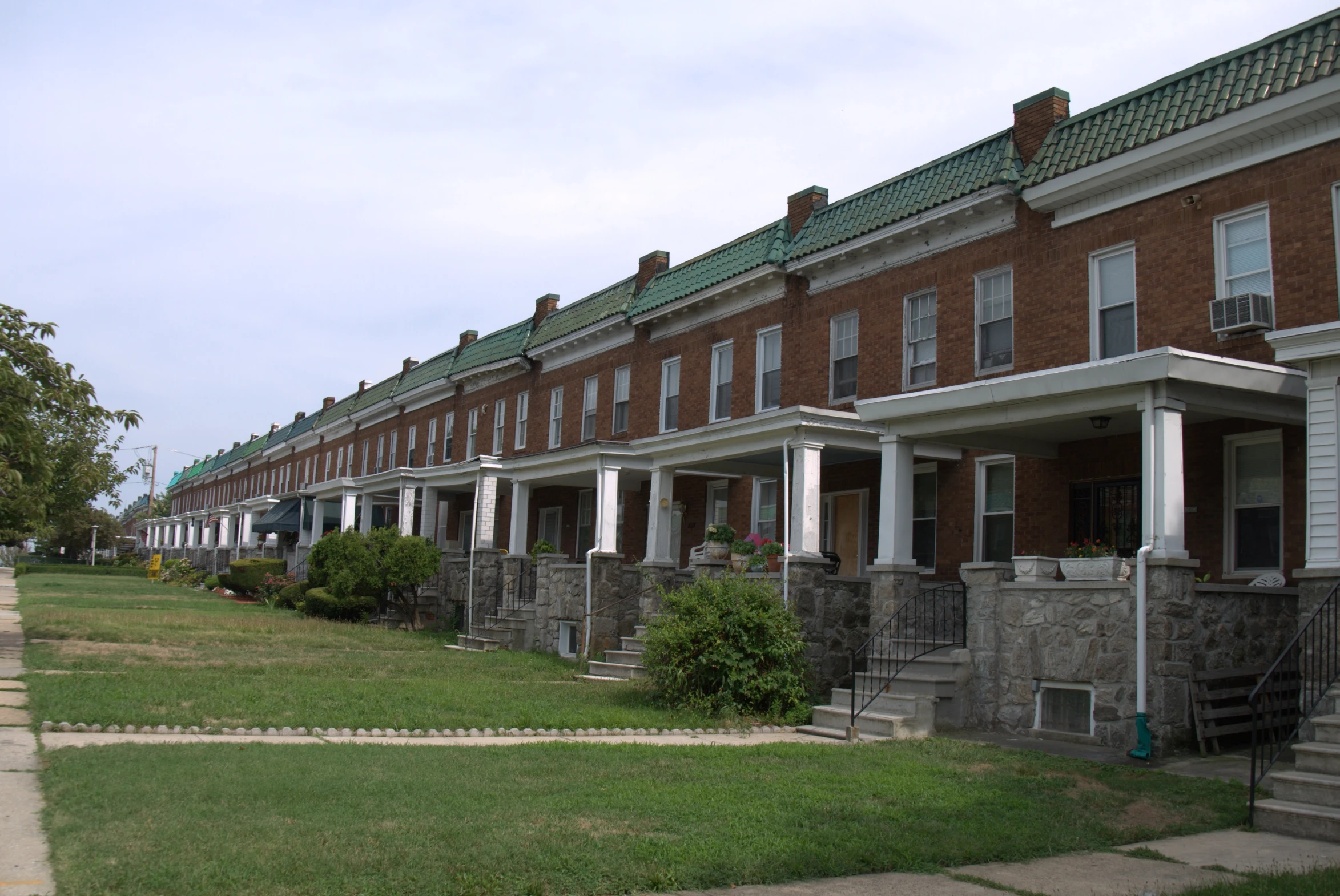 rows of houses with stone railings and flowers on the grass