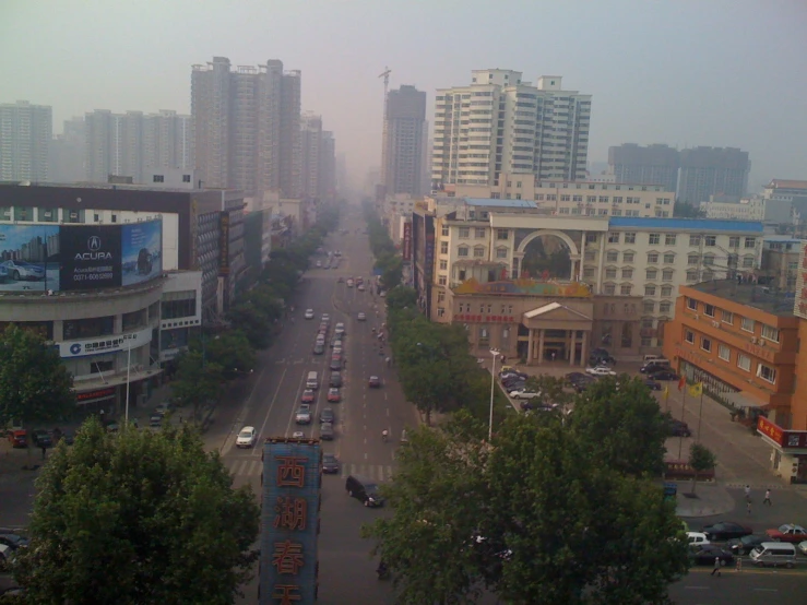 a hazy street in a city with tall buildings