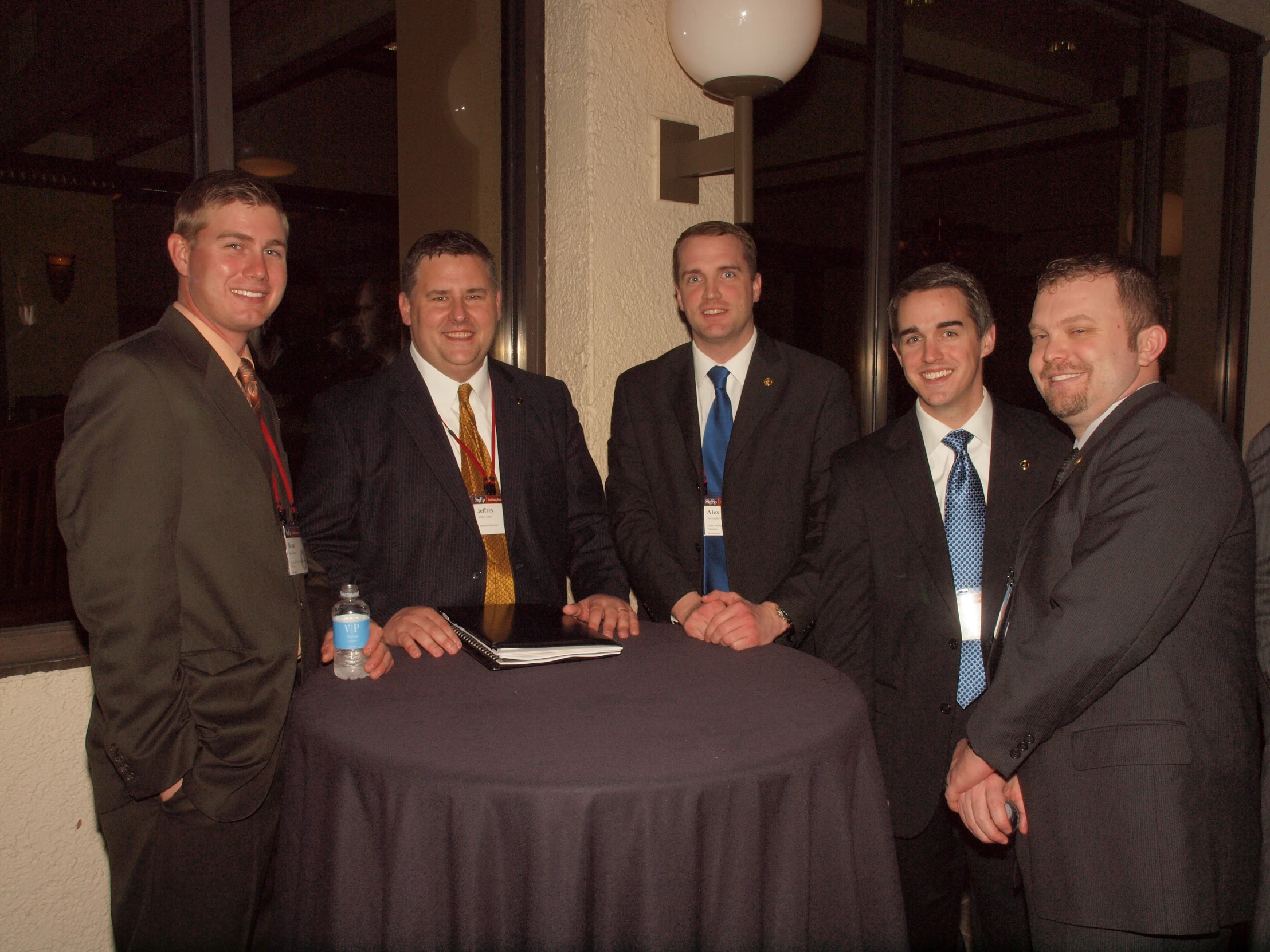 a group of young men standing in front of a table