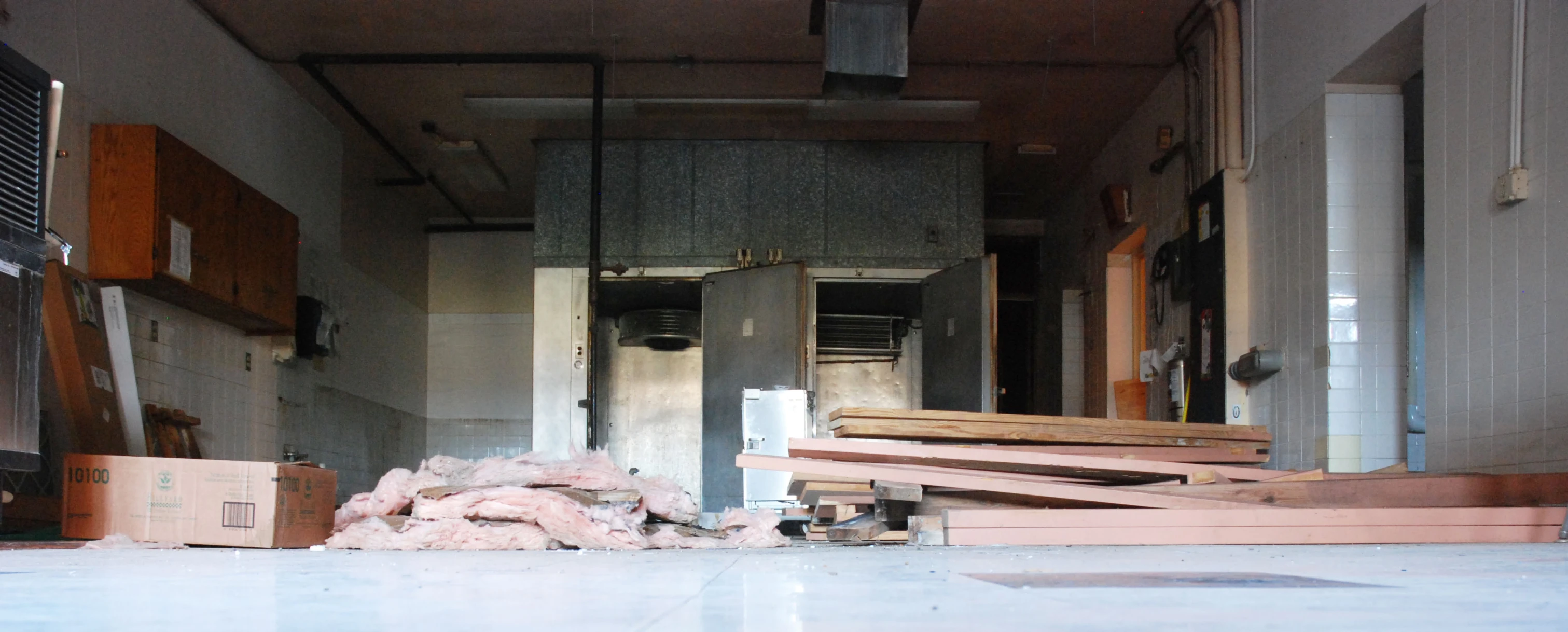 the interior of a rundown apartment with furniture piled on floor