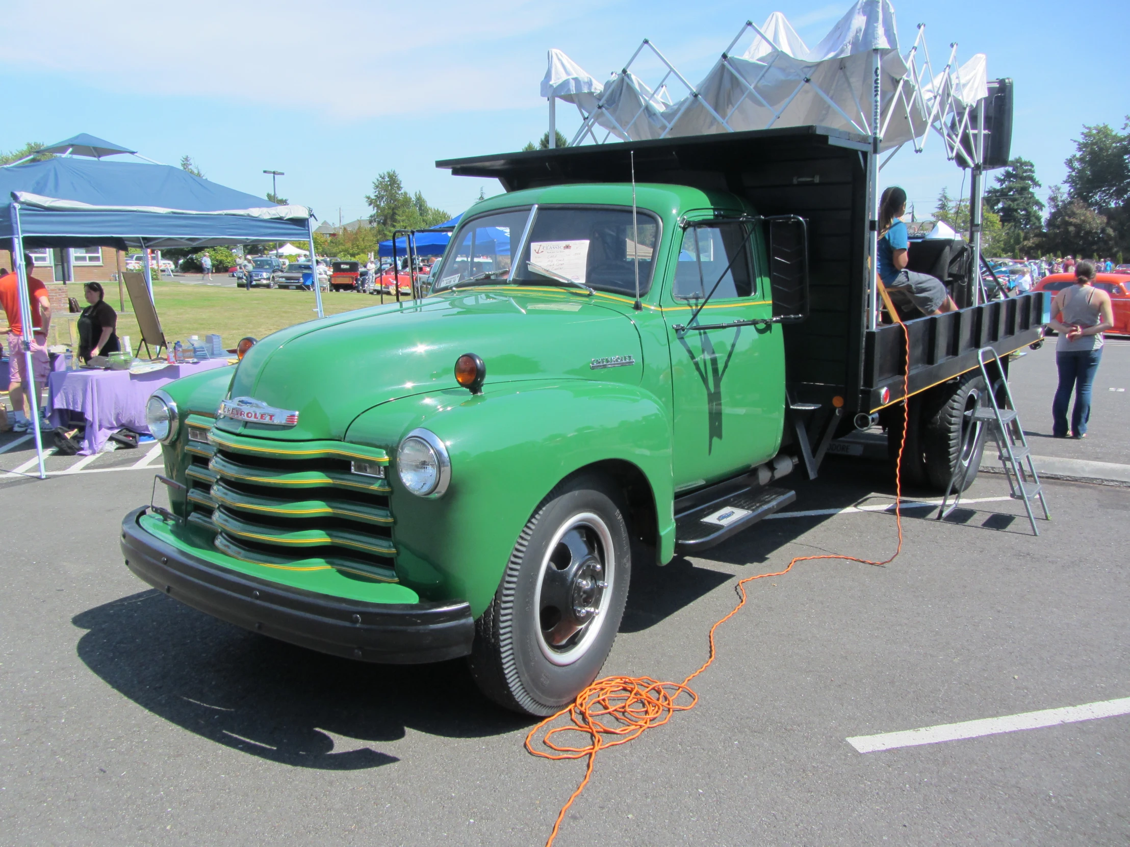 a green truck with an antenna on its bed