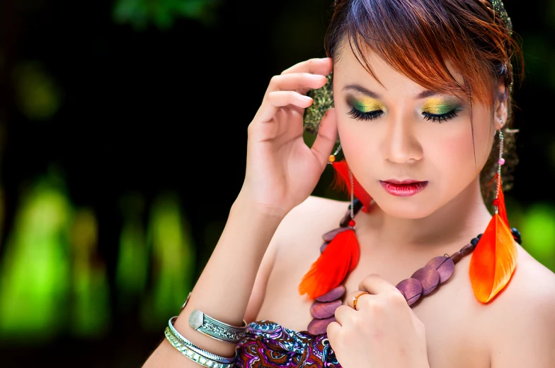 a beautiful woman with bright colored makeup wearing feathers