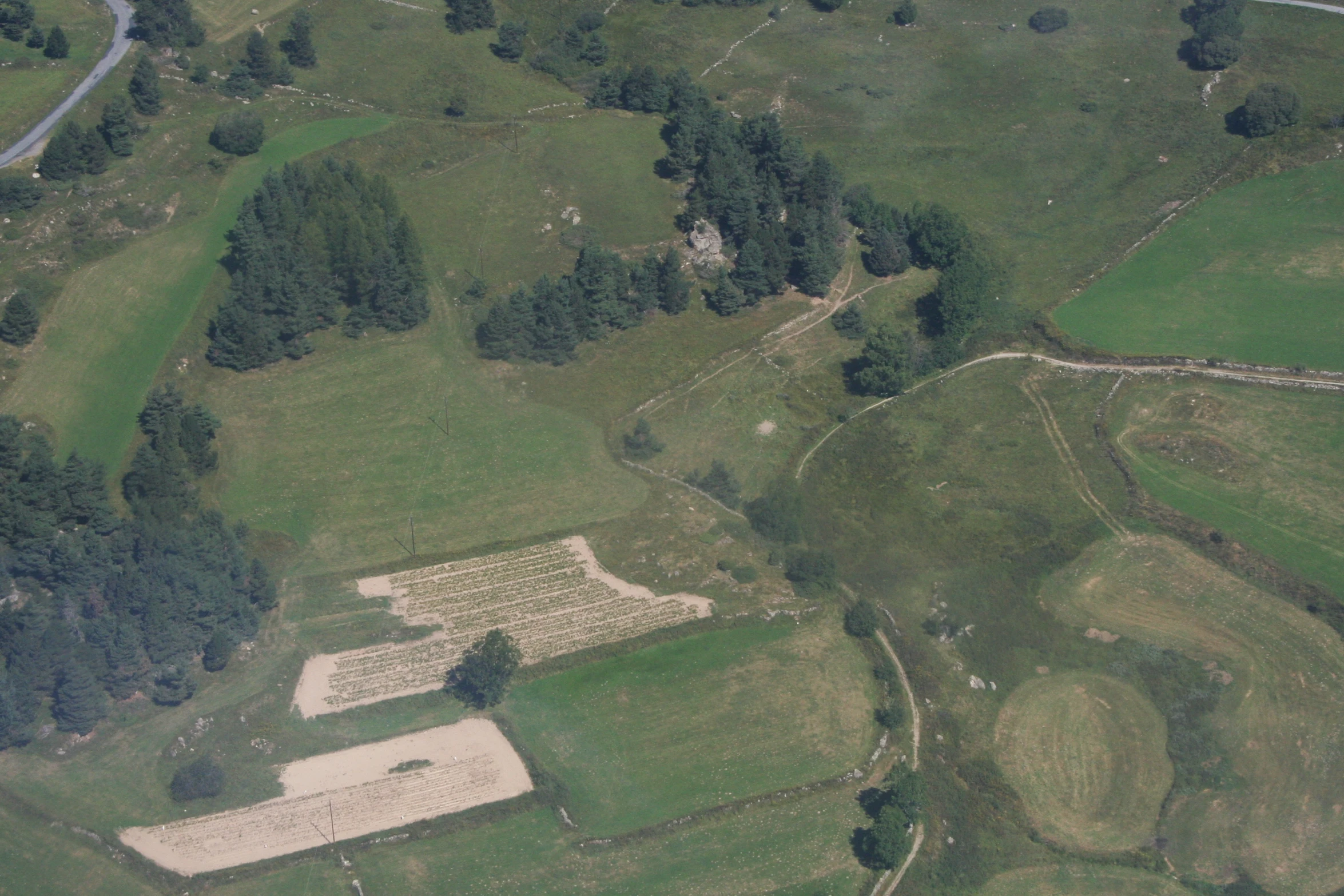 an aerial view of a grassy field in the countryside