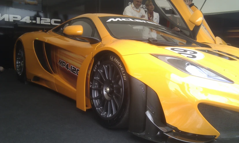 a yellow sports car parked inside a garage