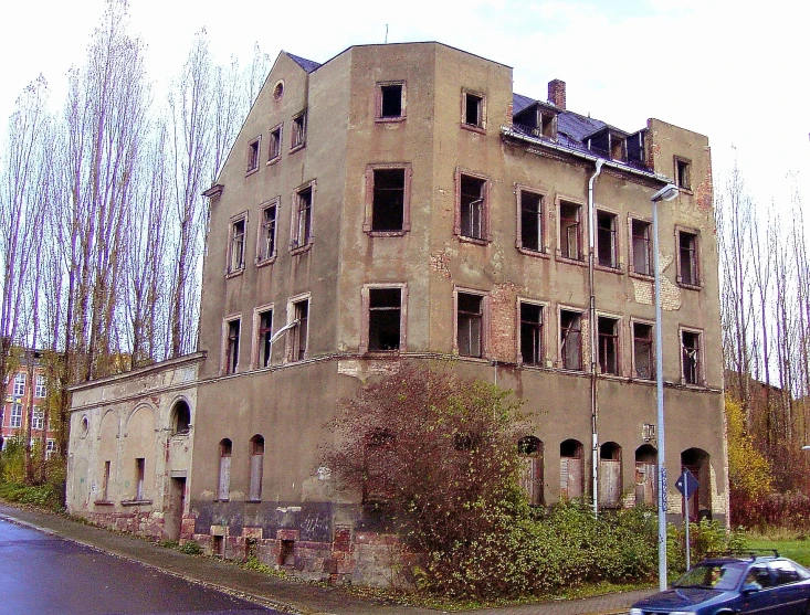 the large building has windows and a lot of vegetation