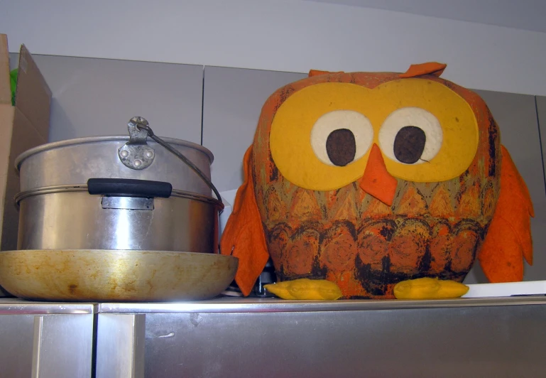 an owl statue and pot in the kitchen