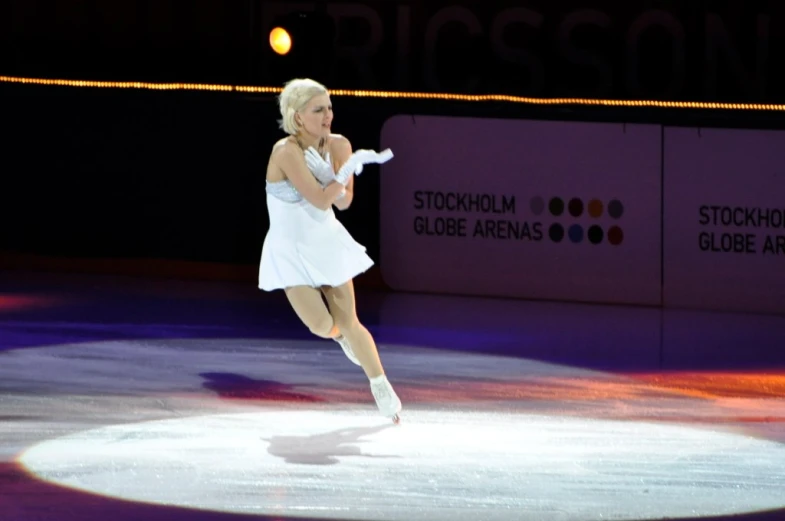 a female figure skating on a rink wearing a dress