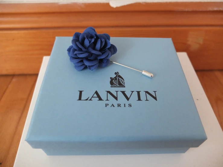 a decorative blue lapel flower sitting on top of a blue box