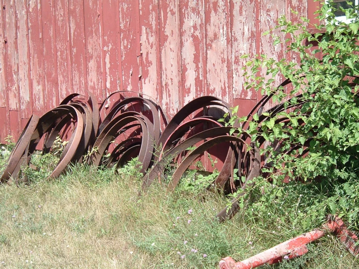 old rusty tires are lined against a red building