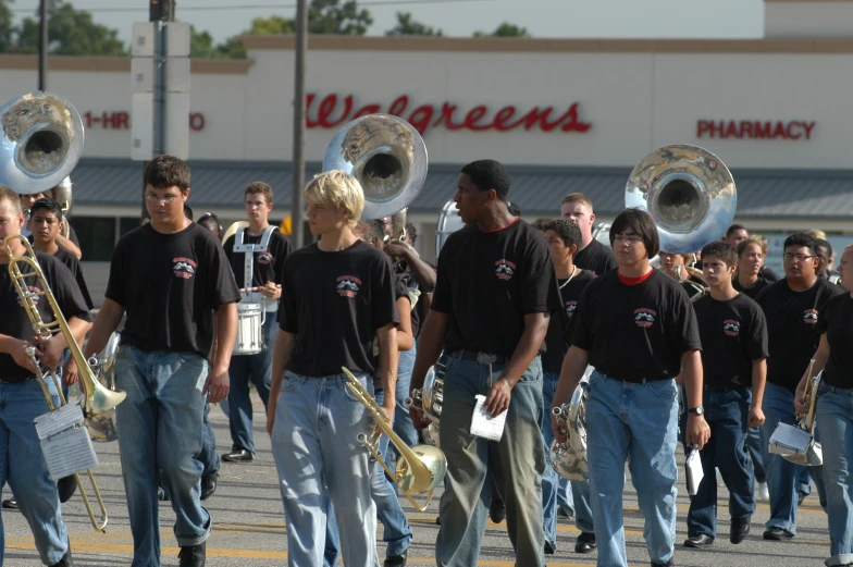 several marching bands walking on the street holding their instruments