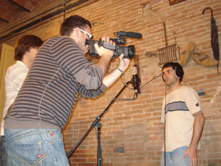 a man recording while another man plays guitar