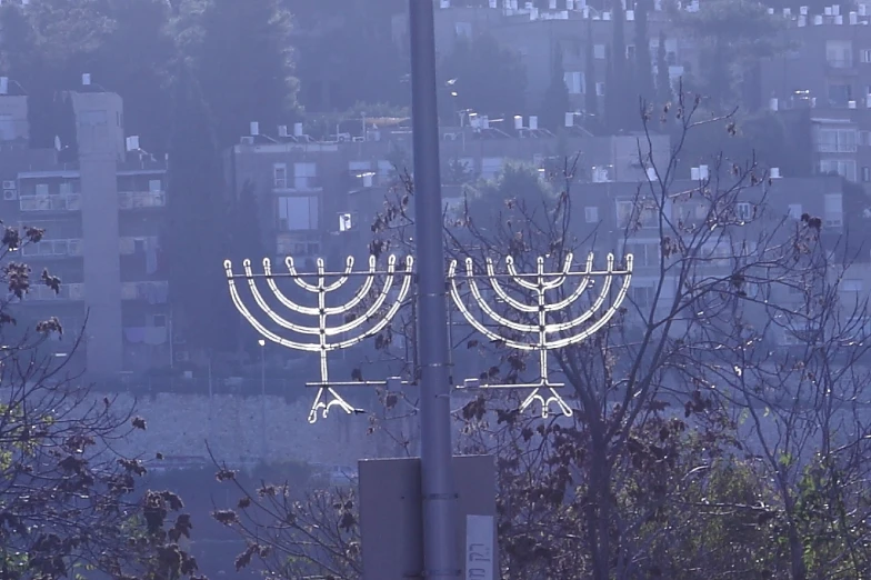 two lit menorahs are on display in front of a city