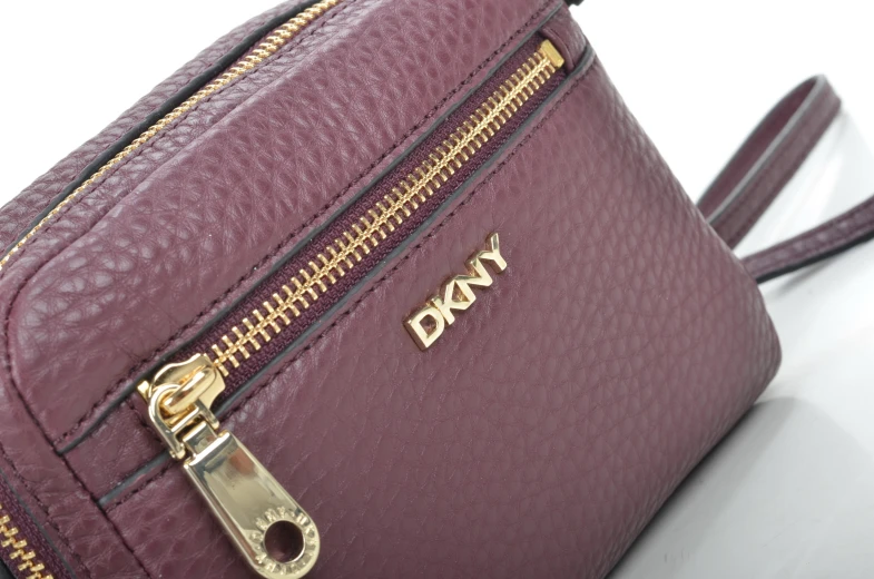 this is a burgundy purse with zipper and metal decorations on it