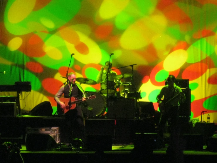 a band with instruments and green lights on the stage