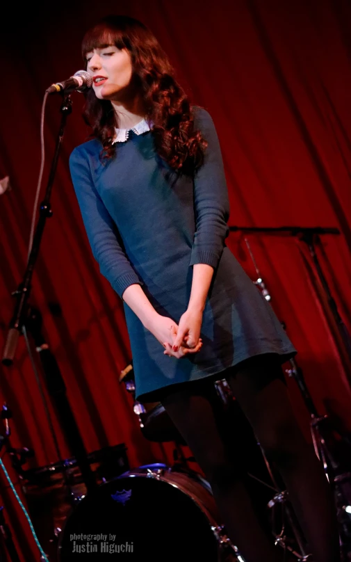 a woman that is standing up on a microphone