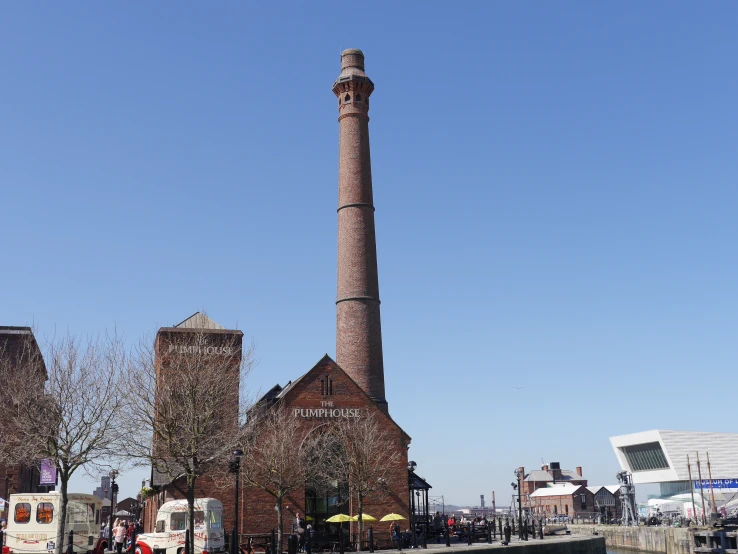 a large brick tower with a clock at the top near buildings
