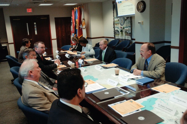 a group of people sitting at tables with papers