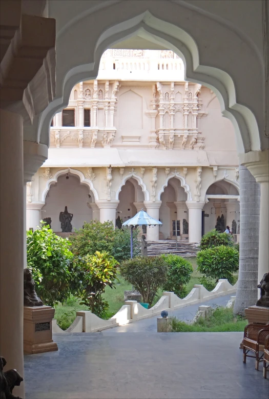 an elaborate building with some arches and a blue umbrella