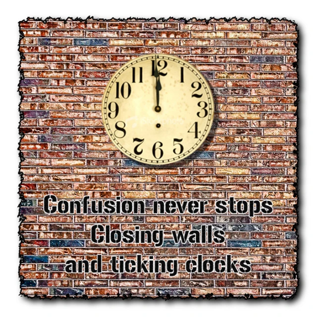 a clock on top of brick wall with words below it