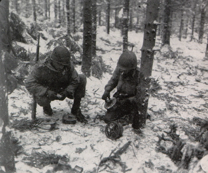 a group of men standing on top of a forest covered in snow