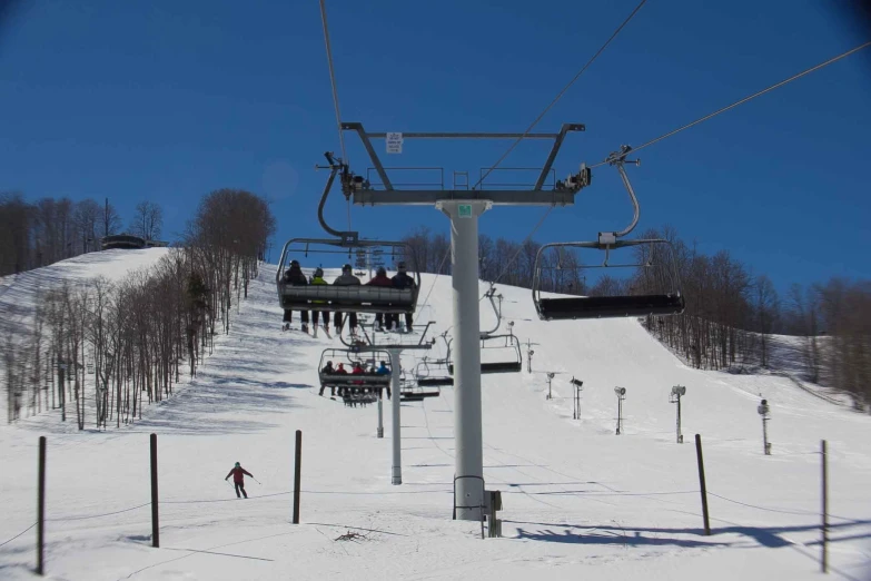 people are skiing on the ski lift at the top