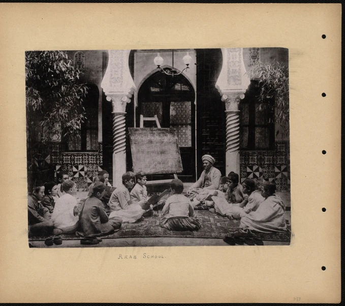 old pograph of men sitting in front of an oriental structure