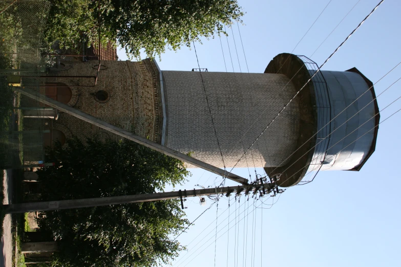 a white brick water tower with electric wires above it