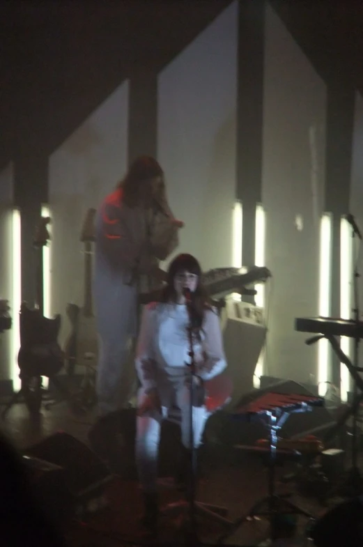 the band is performing in the studio, under lights