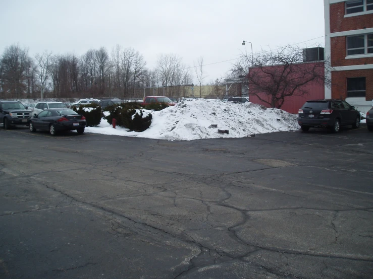 a pile of snow sits next to a parking lot