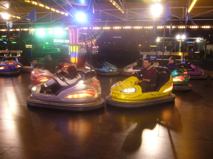 several people riding bumper cars on an indoor ride