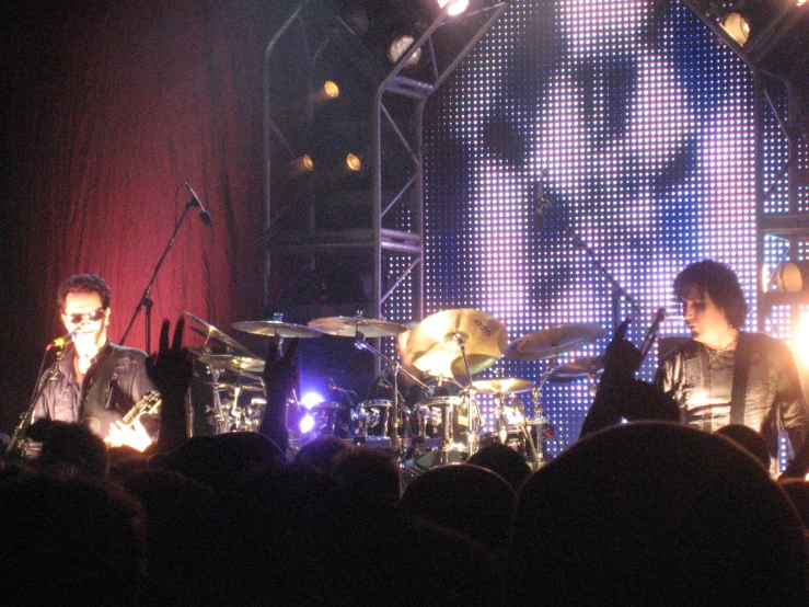 drummers and drums perform on stage while an audience watches