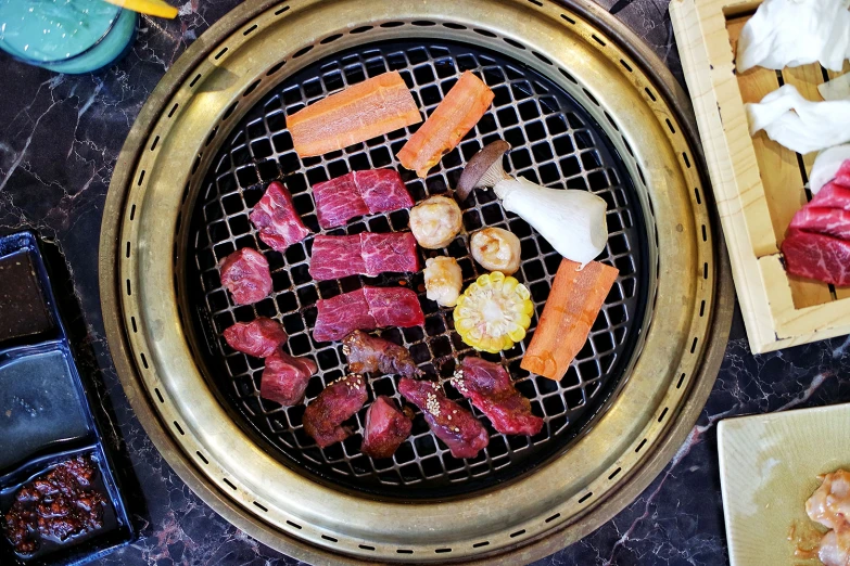 asian style food being cooked over a gridded grill