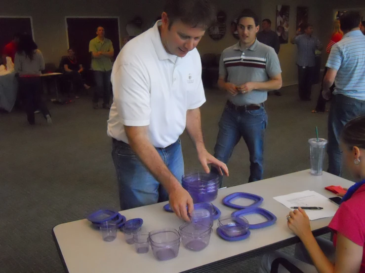 a group of people that are playing with some purple cups