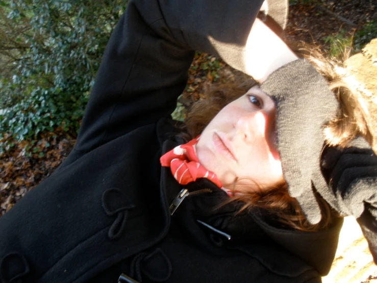 a girl with brown hair posing for a po in a black coat