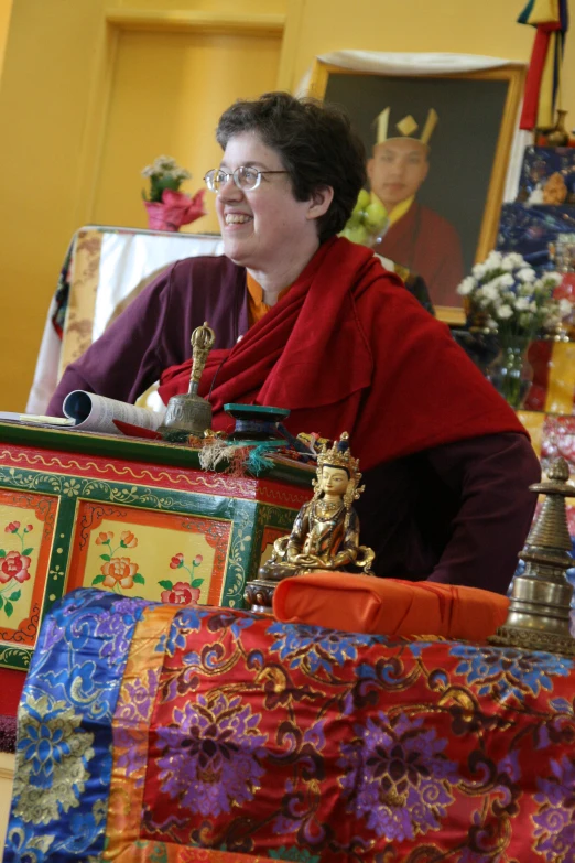 a smiling buddhist woman in a red robe