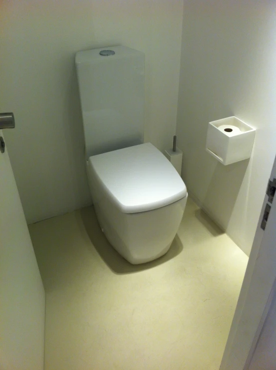 a modern toilet in the corner of a small bathroom