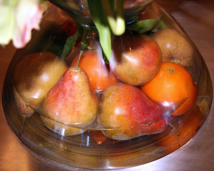 fruit displayed in a clear bowl on a table