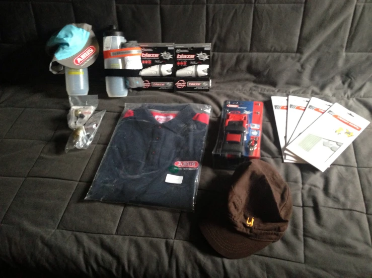 a hat, cap, gloves and other items are sitting on the bed