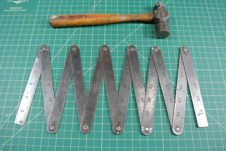 some metal pieces are being cut and placed next to a wrench