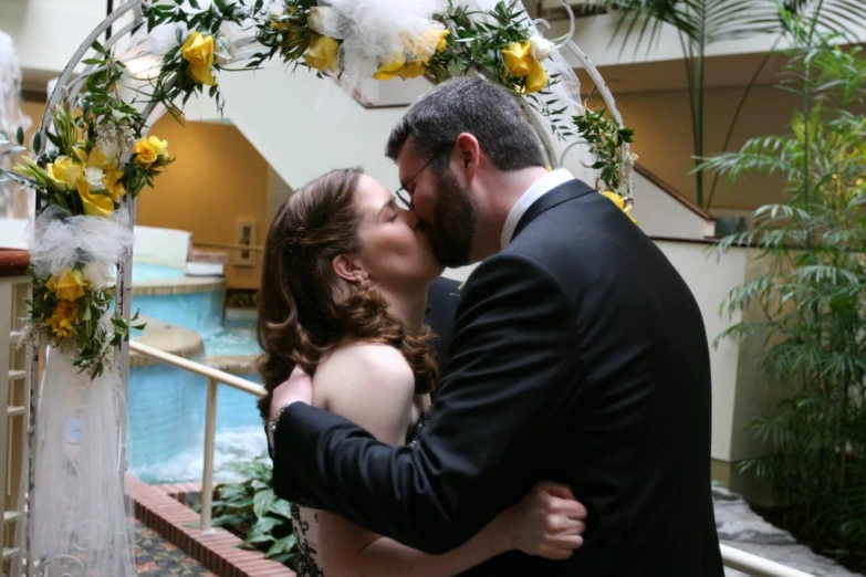 a couple is in their wedding day by a fountain