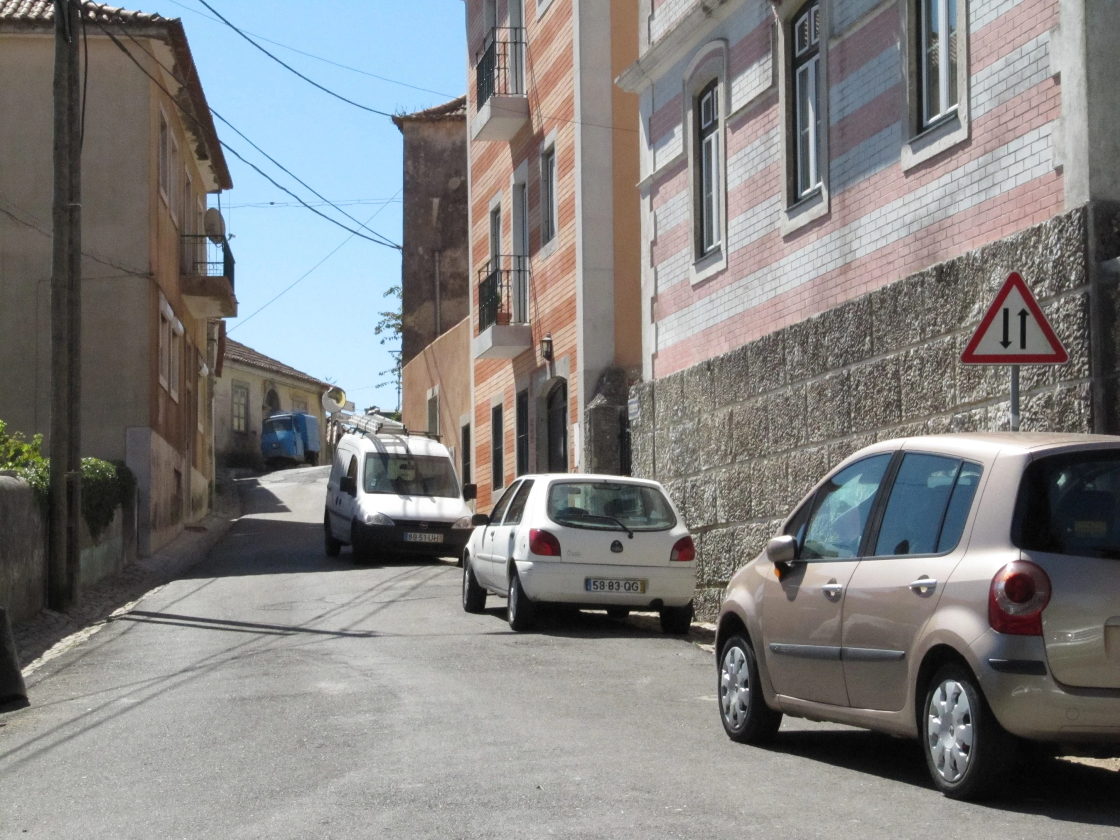 three cars are parked in front of a brick wall