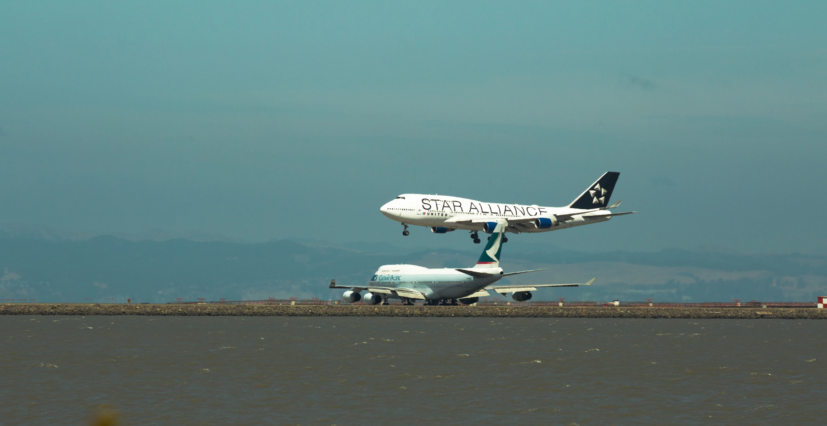 two planes in the air with each other on the runway